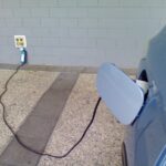 An electric vehicle plugged into a wall to charge