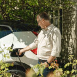 man charging EV at home