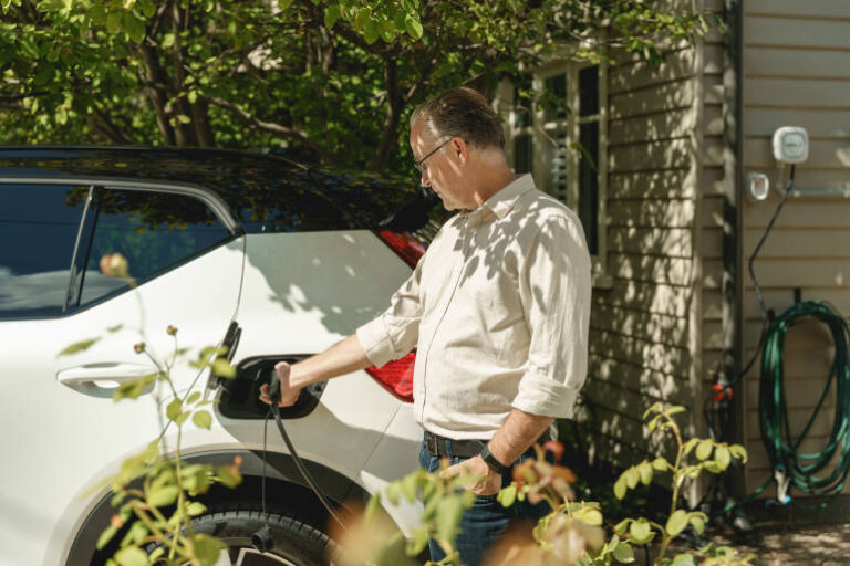 man charging EV at home