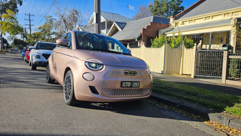 Fiat 500e on street in pastel pink