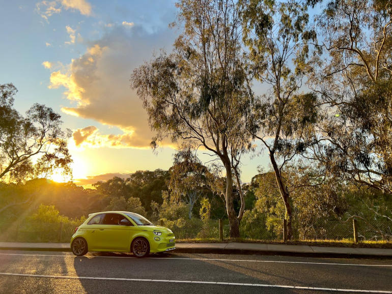 Fiat Abarth 500e on country road with sunset