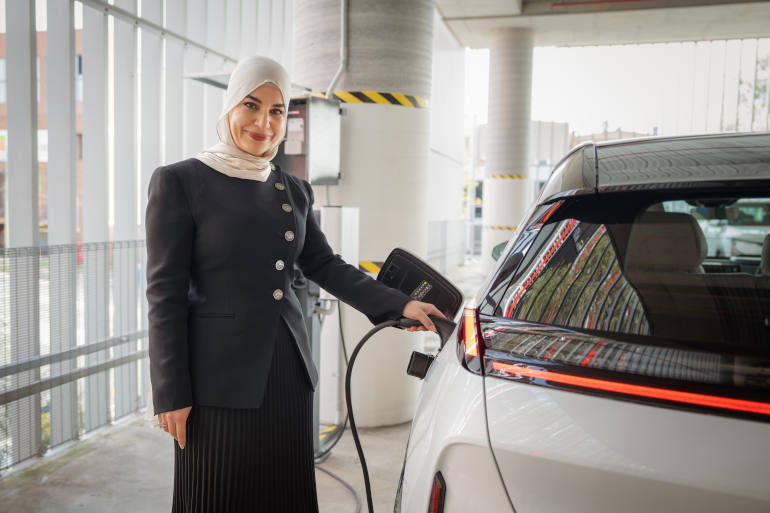 Lady charging a electric vehicle